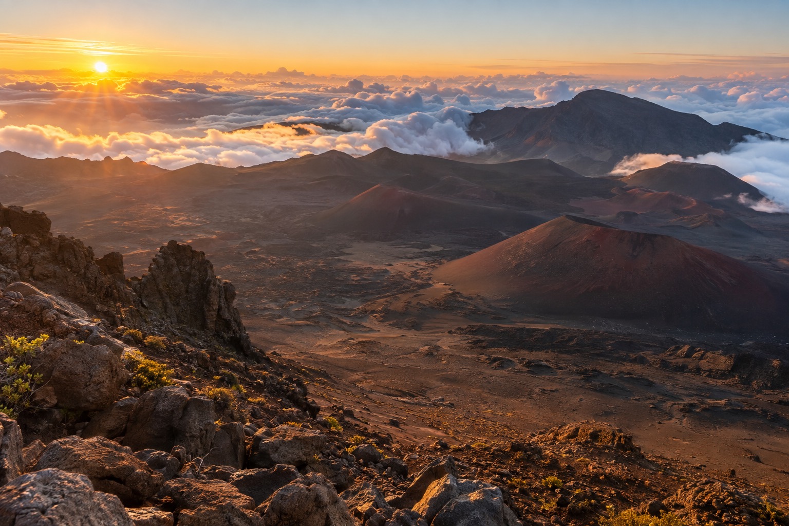Sunrise light breaking over cloud layers seen from the summit of Haleakala