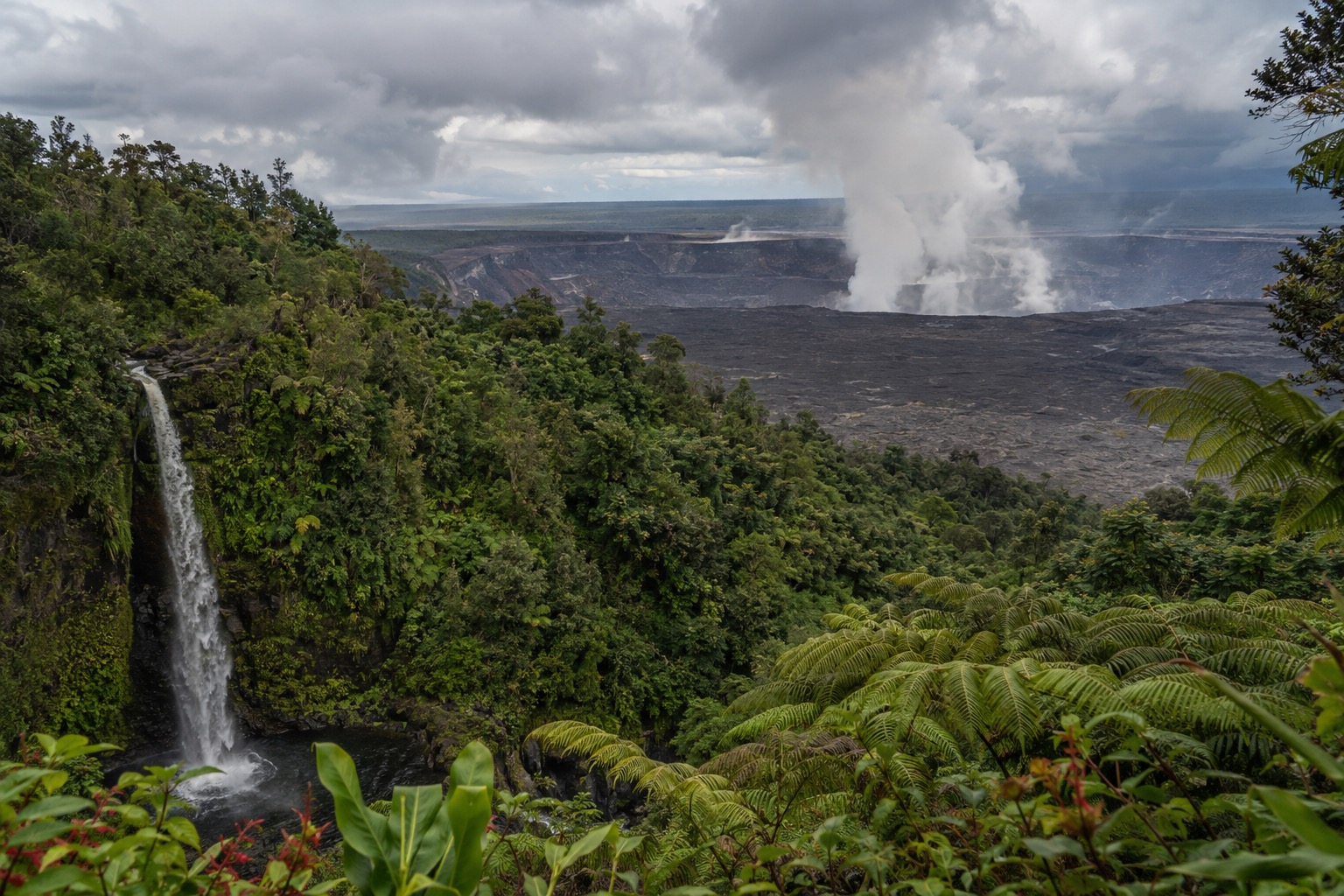 Steam rising from the Kīlauea caldera at Hawaii Volcanoes National Park under a cloudy sky