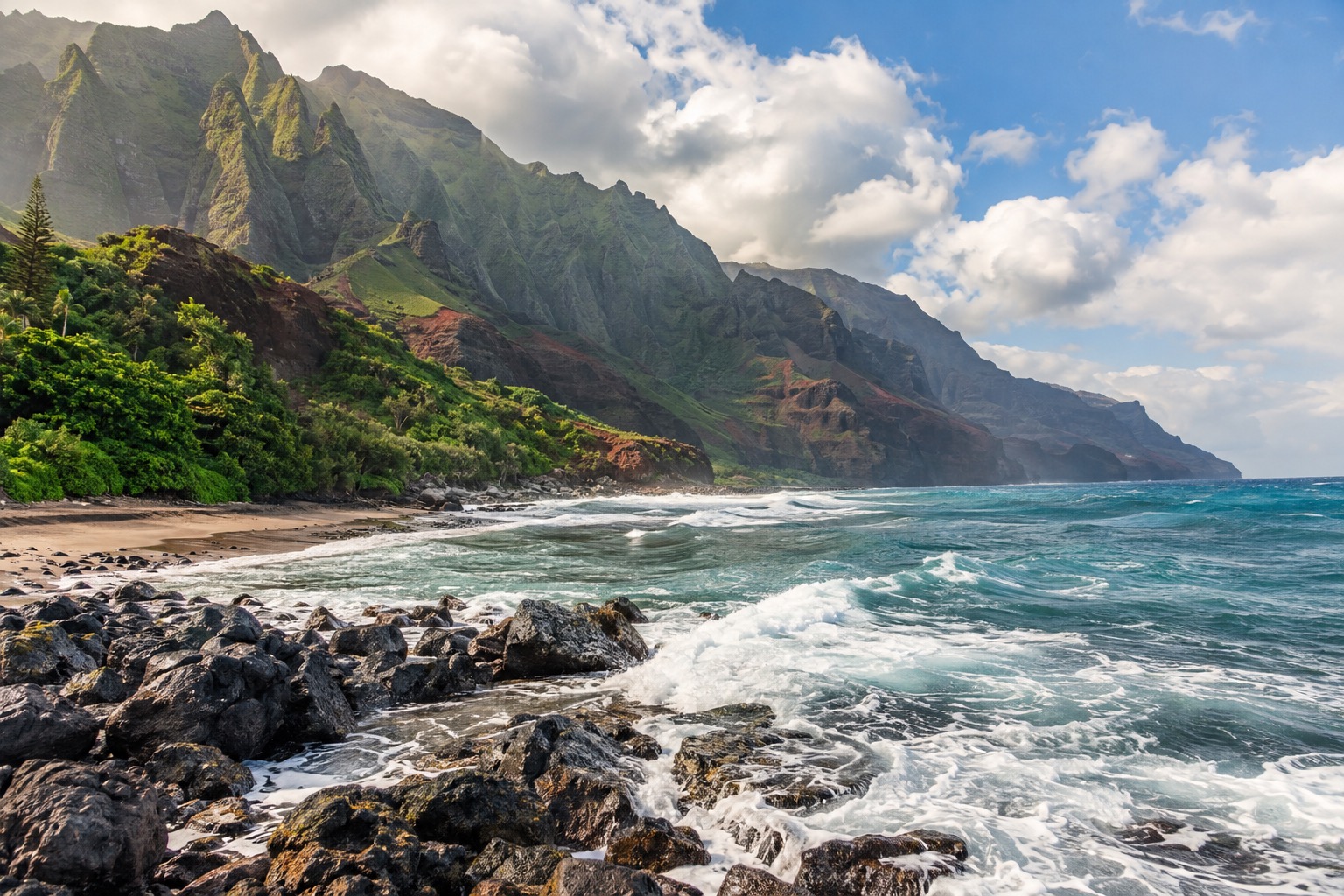 Waves rolling onto a rocky beach point on Kauai's south shore