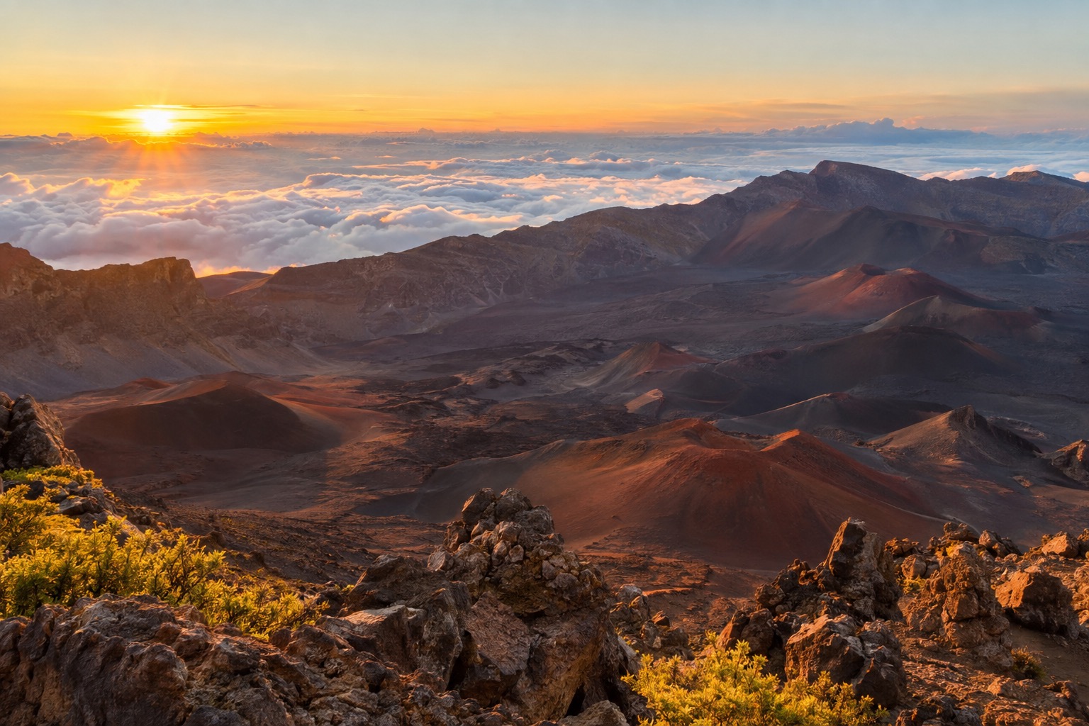 Sunrise light over red and black cinder cones inside Haleakalā's summit crater