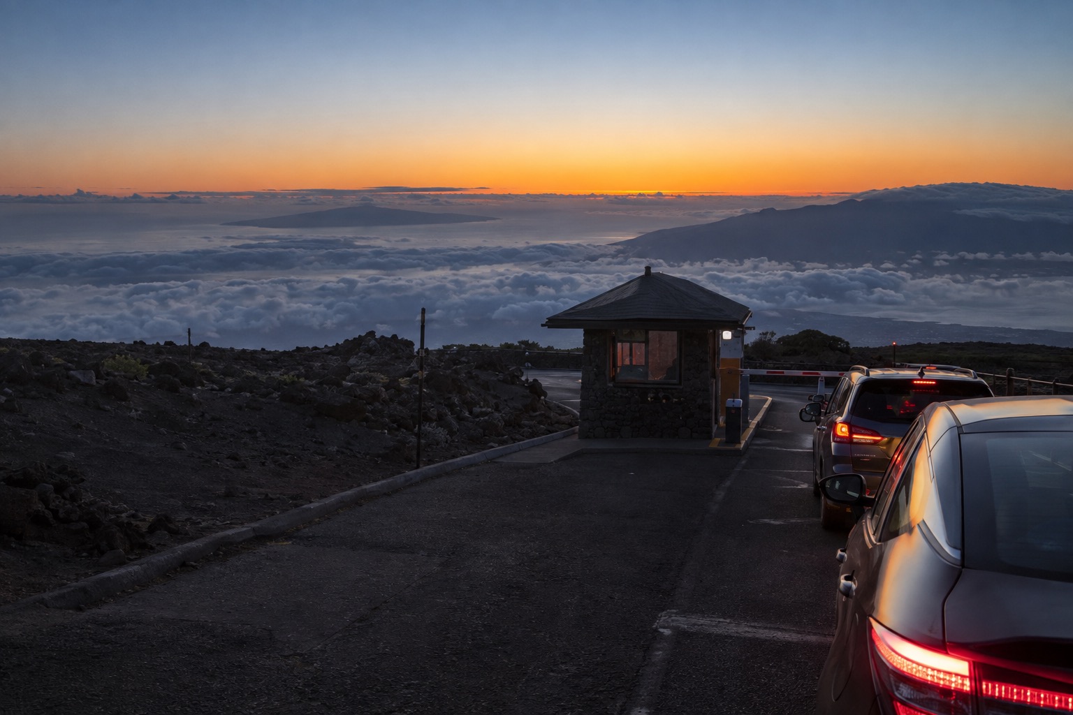 Cars waiting at a gate before dawn on the road up Haleakala volcano