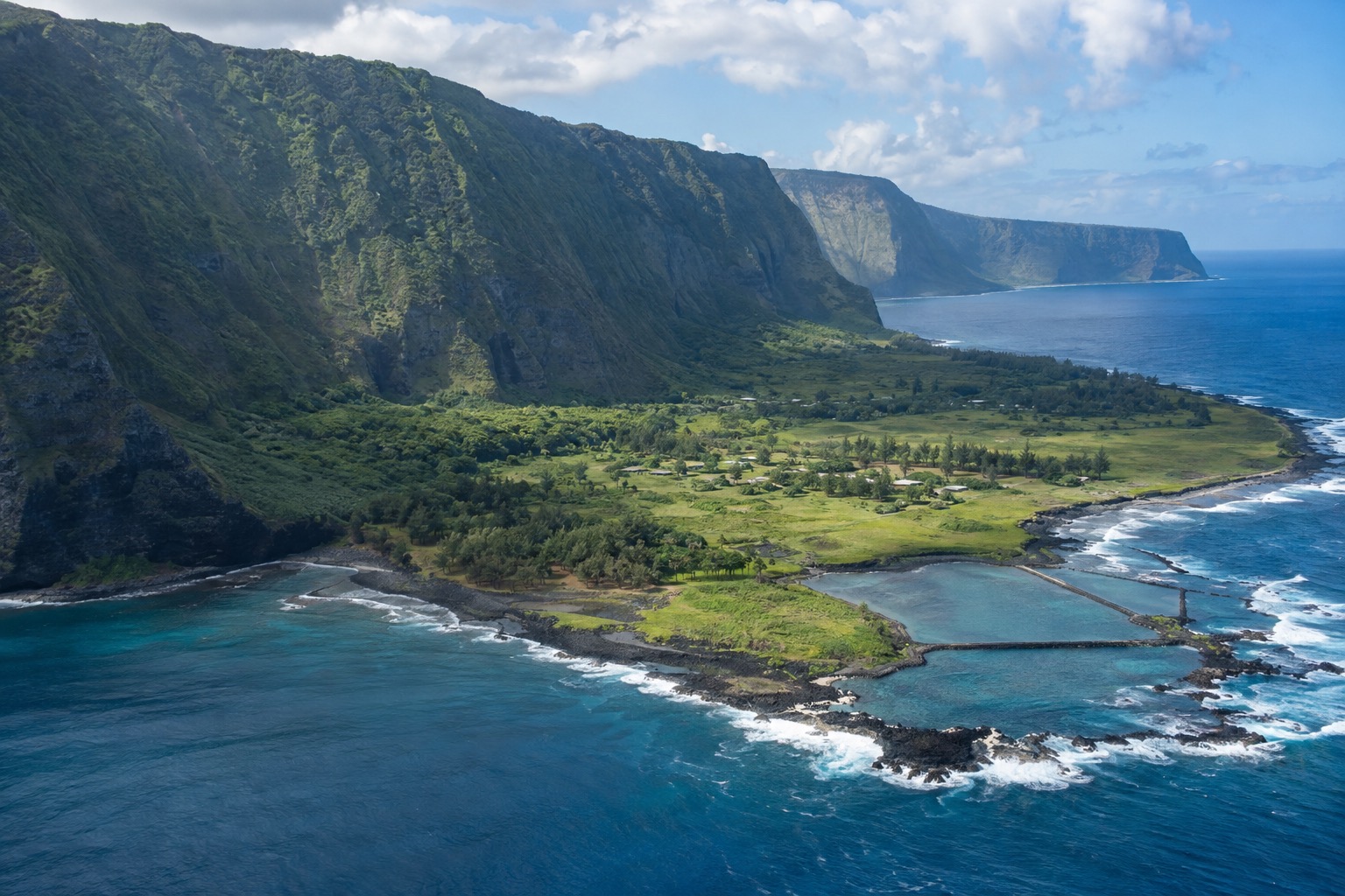 The Kalaupapa Peninsula seen from above, backed by tall sea cliffs