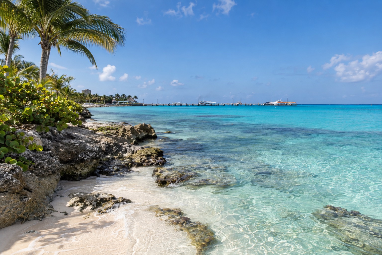 Calm turquoise water along the waterfront of San Miguel de Cozumel with a pier in the distance