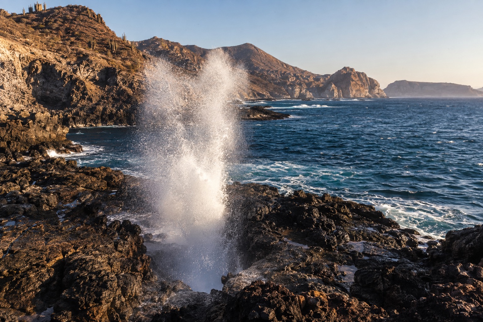Seawater spraying upward from a rocky blowhole along the Baja California coast