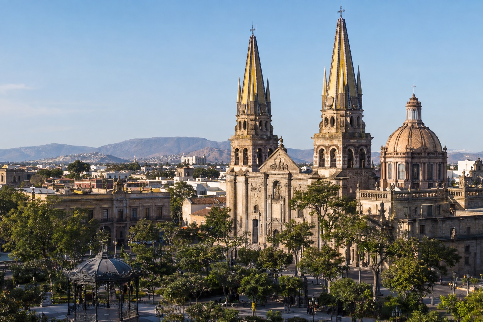 Twin yellow-tiled spires of a large cathedral rising over a sunlit plaza in Guadalajara