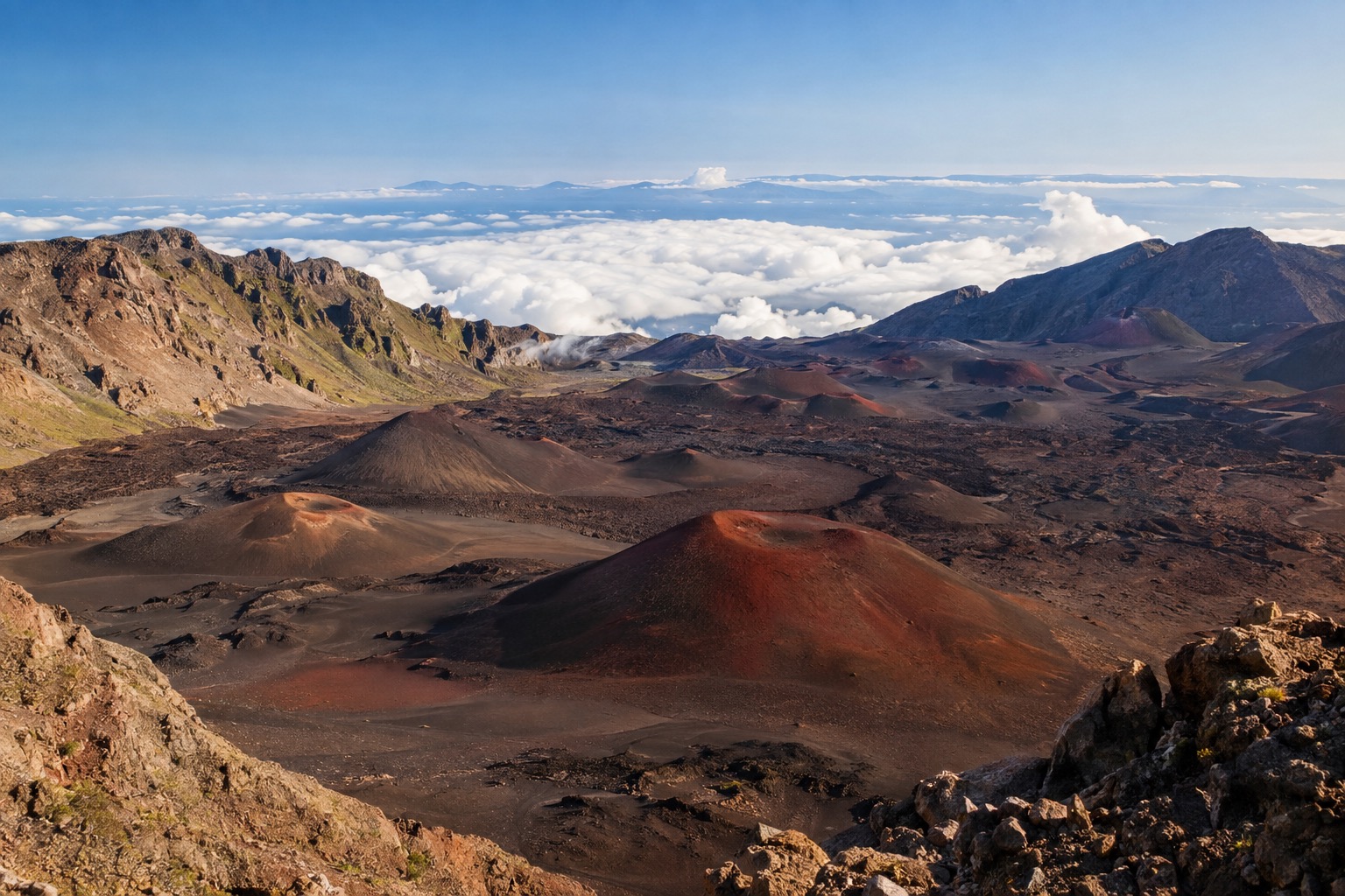 The reddish cinder cones inside Haleakala's summit crater under a clearing sky