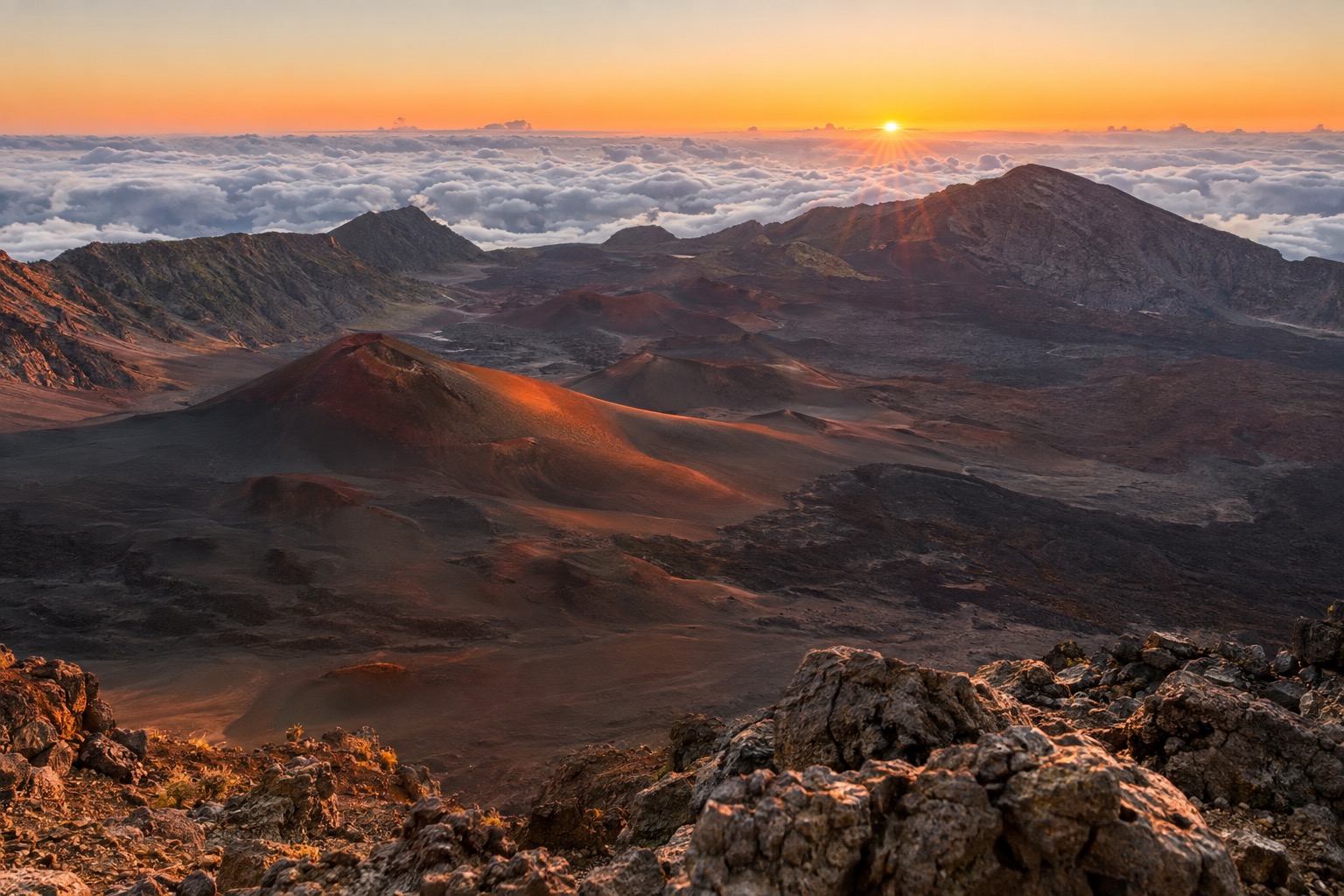 Sunrise light over the red and black cinder cones inside Haleakala's summit crater