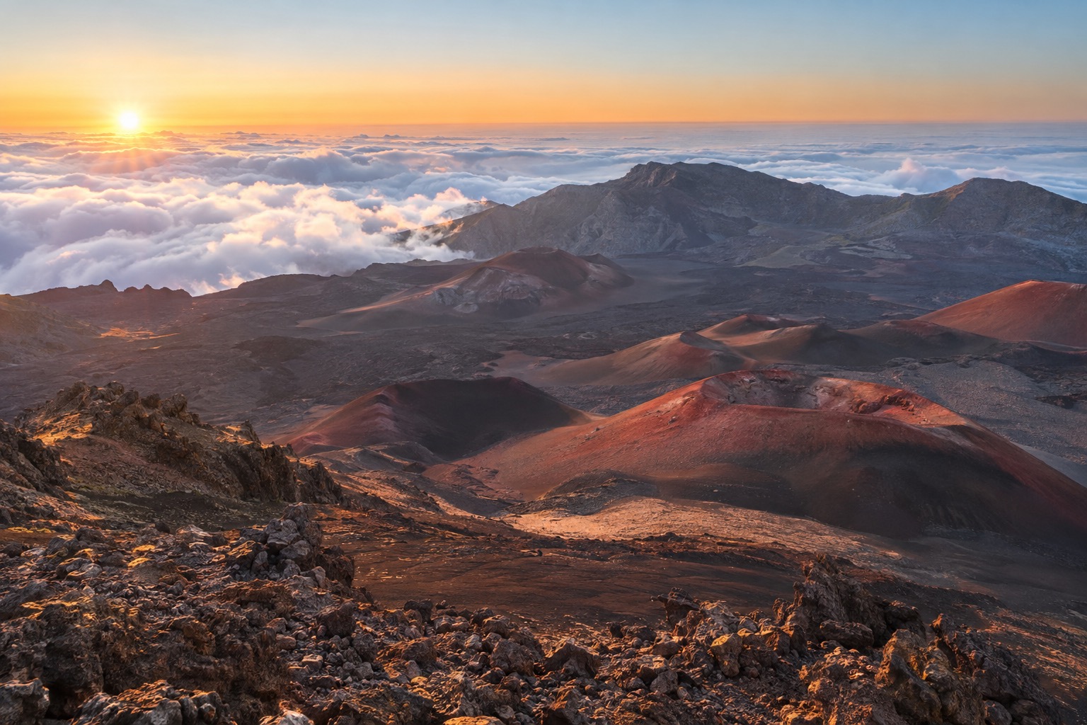 Reddish and black cinder cones inside the Haleakala crater at sunrise