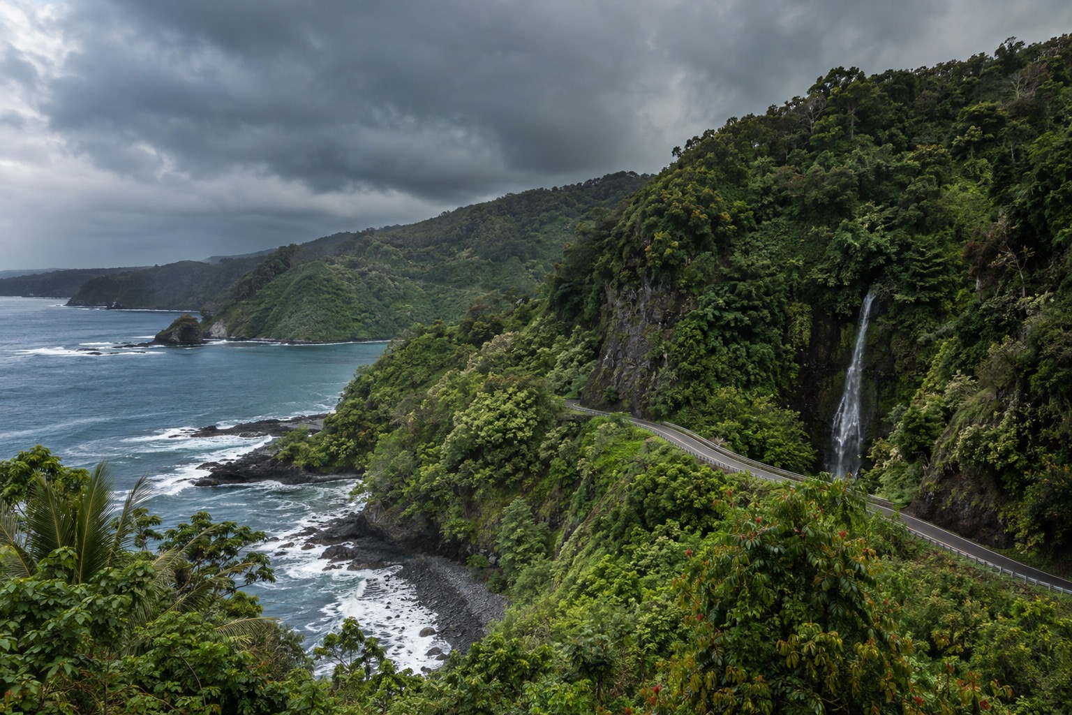 Rain clouds gathering over a green valley along the Hana Highway, Maui