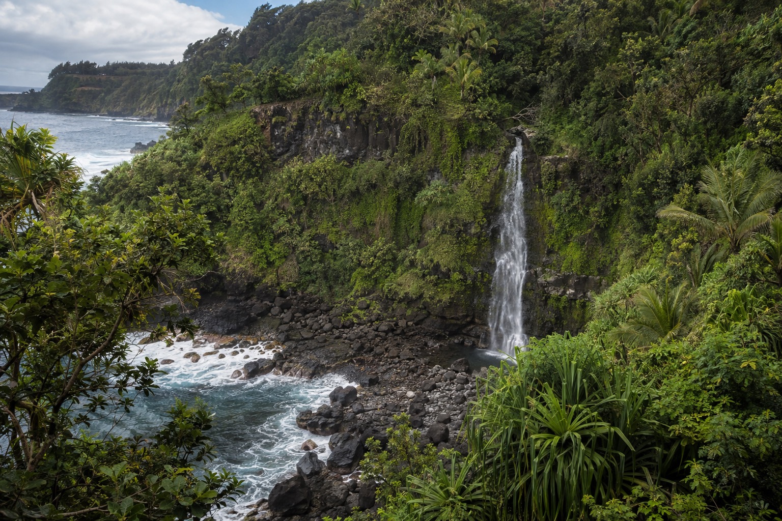 Waterfall dropping through green cliffs near the Kipahulu district of Haleakala National Park