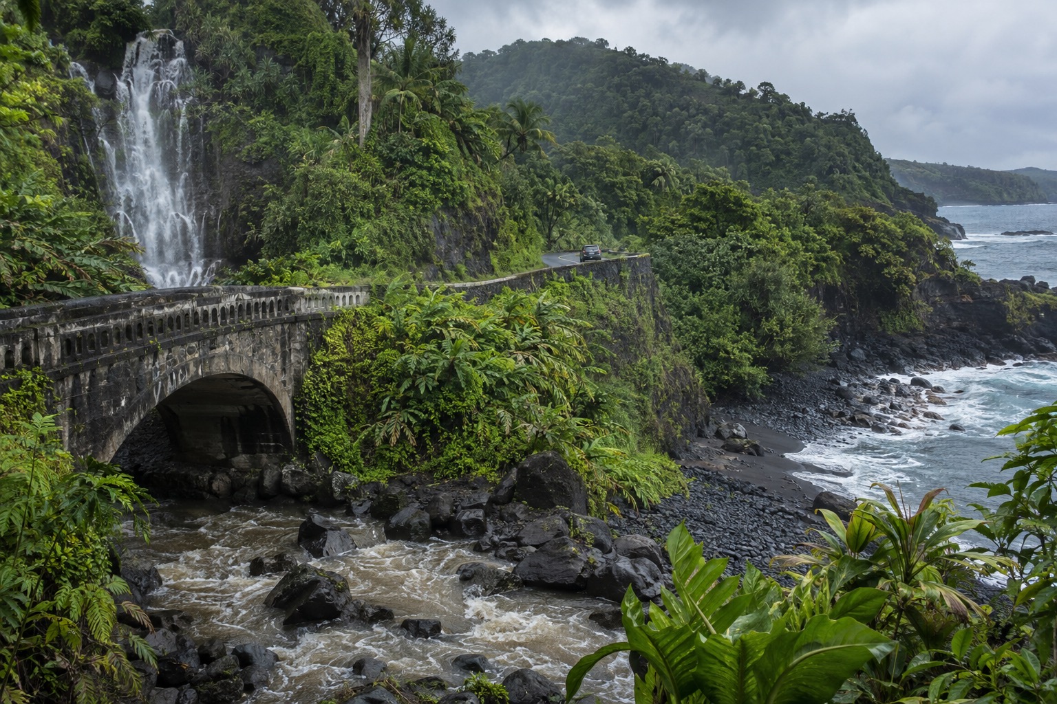 A stone bridge on the Hana Highway crossing a stream swollen with rain