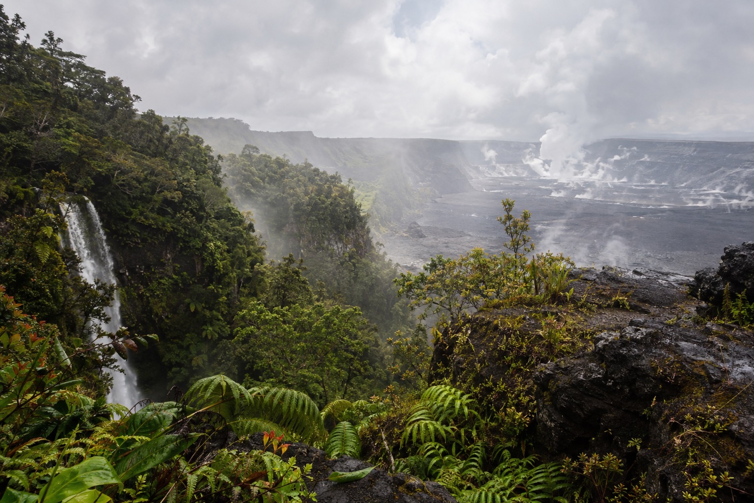 A misty overlook above a steaming volcanic caldera at midday
