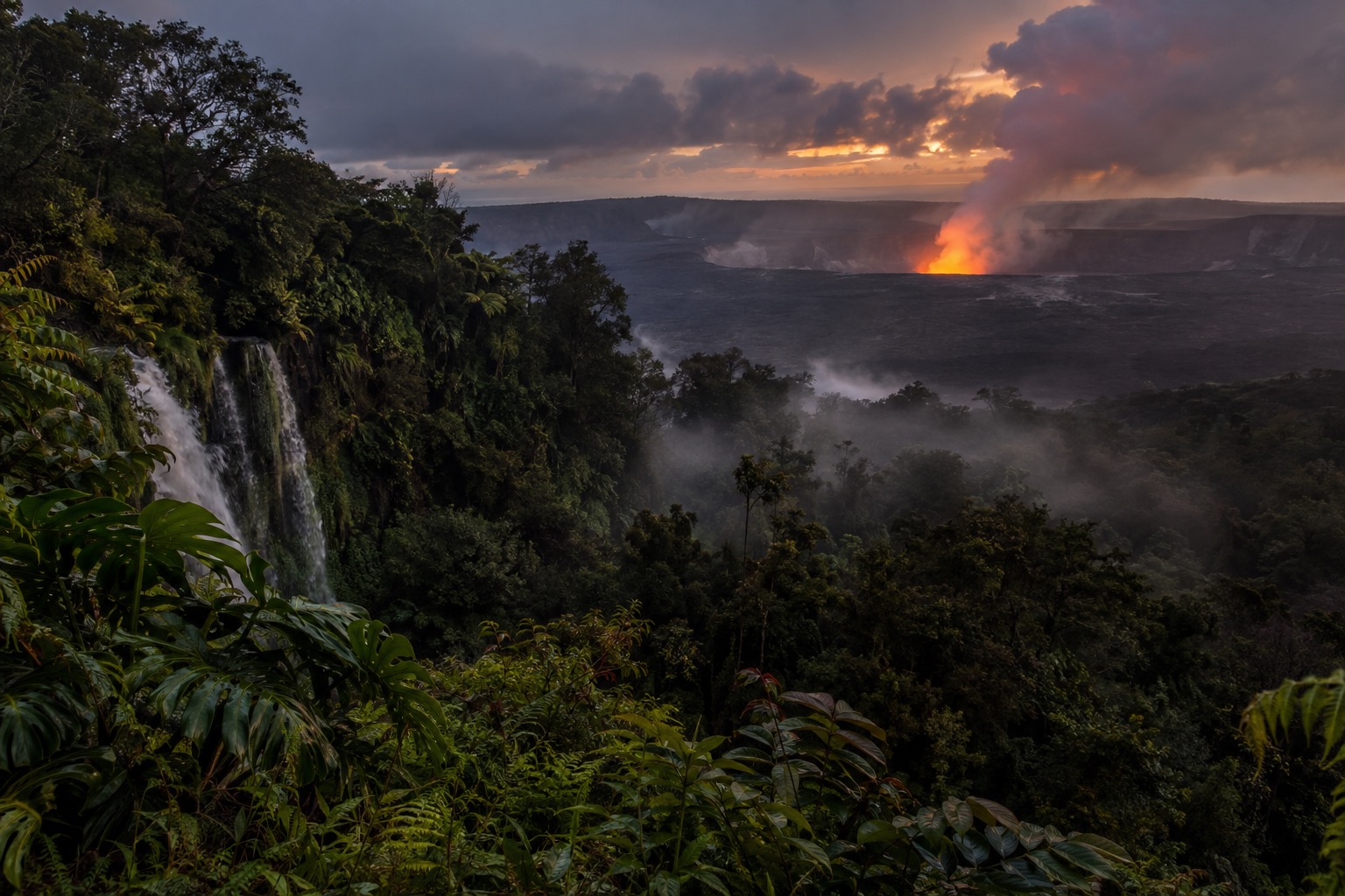 Glow above a volcanic vent at dusk, seen across a dark caldera rim