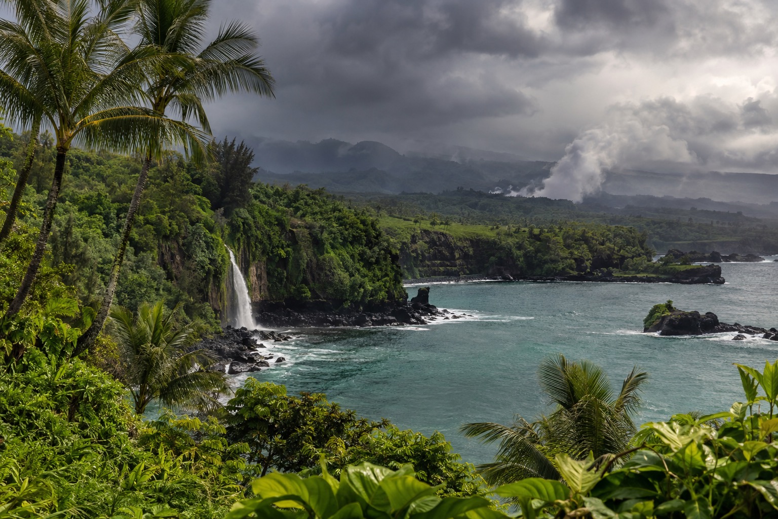 Rain clouds gathering over a green bay with palm trees in the foreground