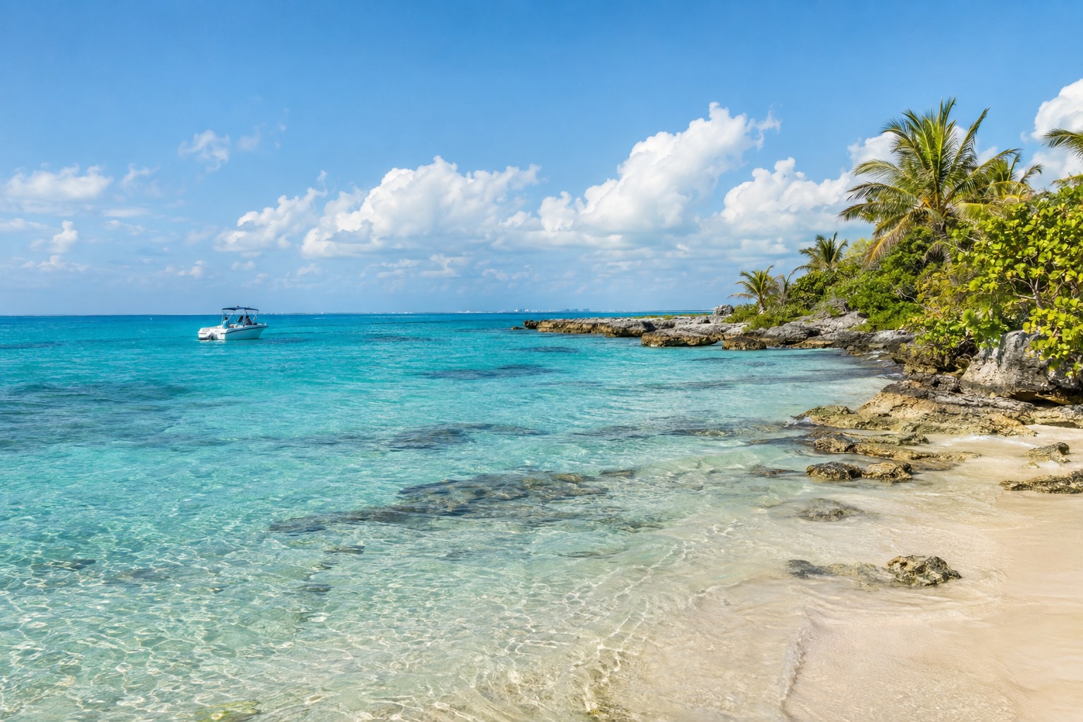 Turquoise Caribbean water off the coast of Isla Mujeres with a small boat in the distance