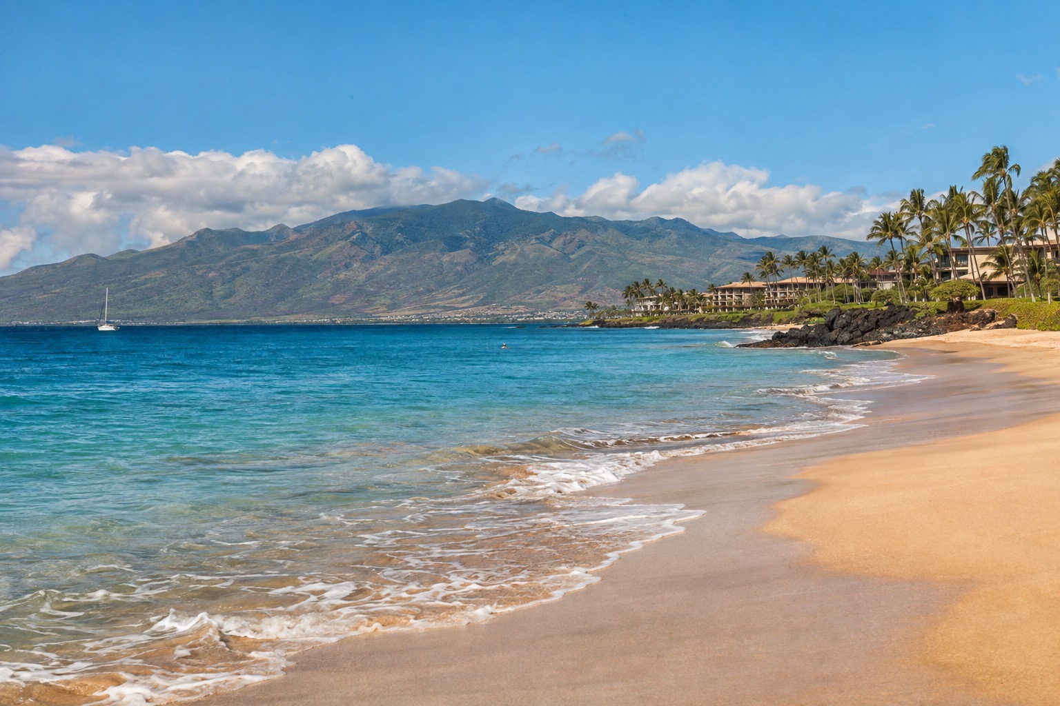 Turquoise water and white sand at Kaanapali Beach with the West Maui Mountains behind
