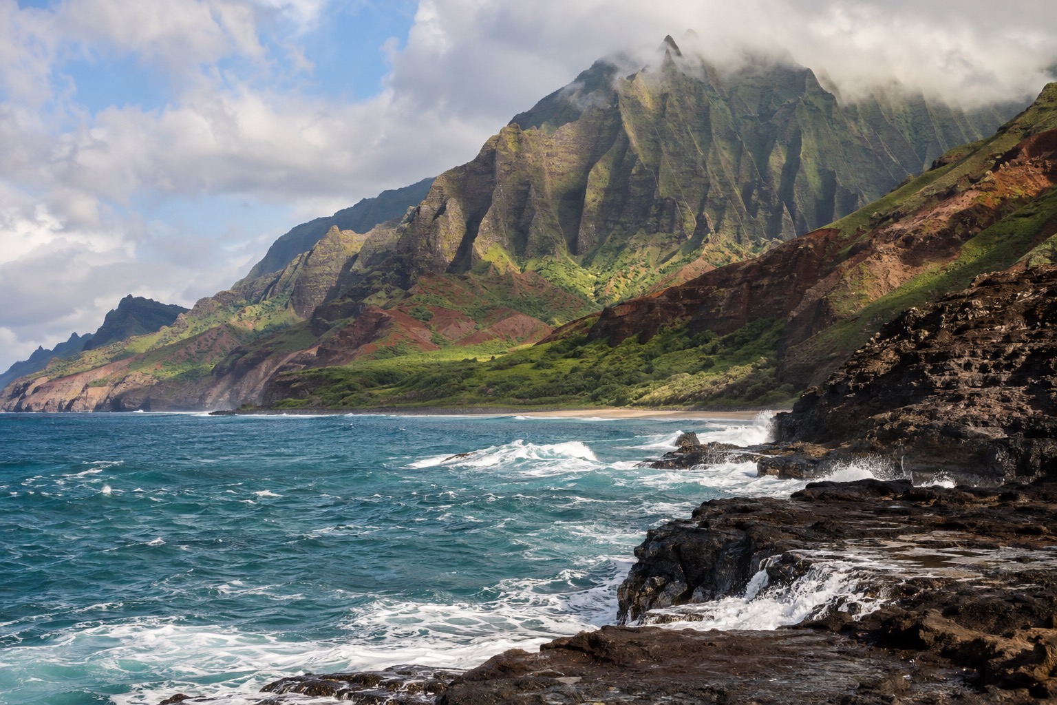 Waves breaking along a rocky stretch of Kauai's coastline under a partly clouded January sky