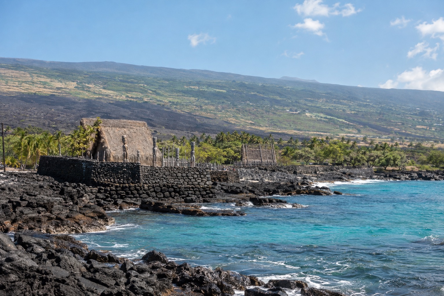 A stone platform and thatched structures at a historical park along Kona's lava coastline