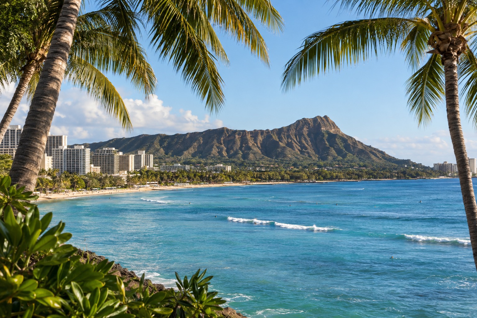 Turquoise lagoon water framed by palm trees along a Hawaii resort shoreline