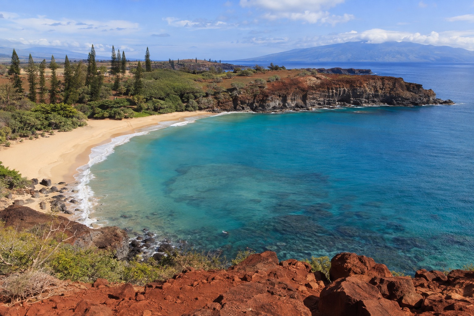 Turquoise water and a crescent white-sand beach backed by cliffs at Hulopoe Bay, Lanai