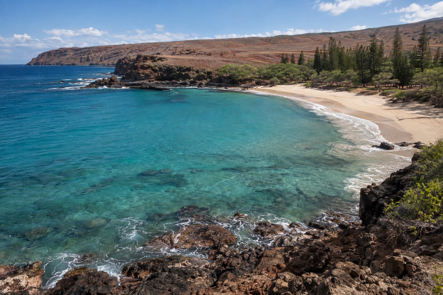 Turquoise water in a sandy cove backed by low cliffs on Lanai's south shore