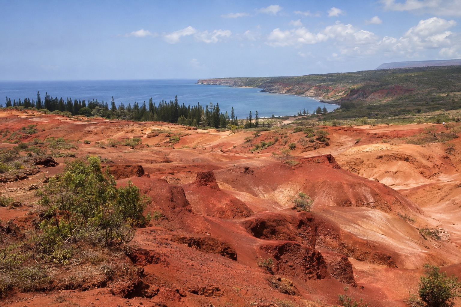 Red and orange eroded rock formations spread across a dry plateau
