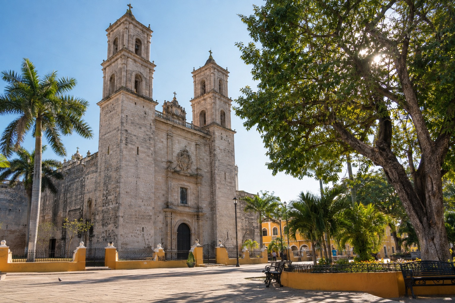 Colonial stone cathedral facade beside a sunlit plaza in Merida, Yucatan, early morning
