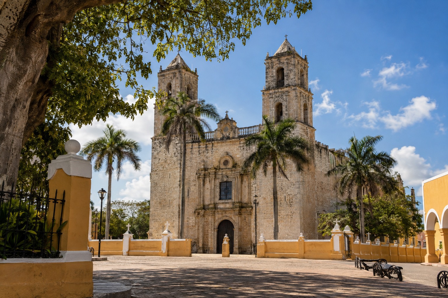 The stone facade of a colonial cathedral seen from a sunlit plaza