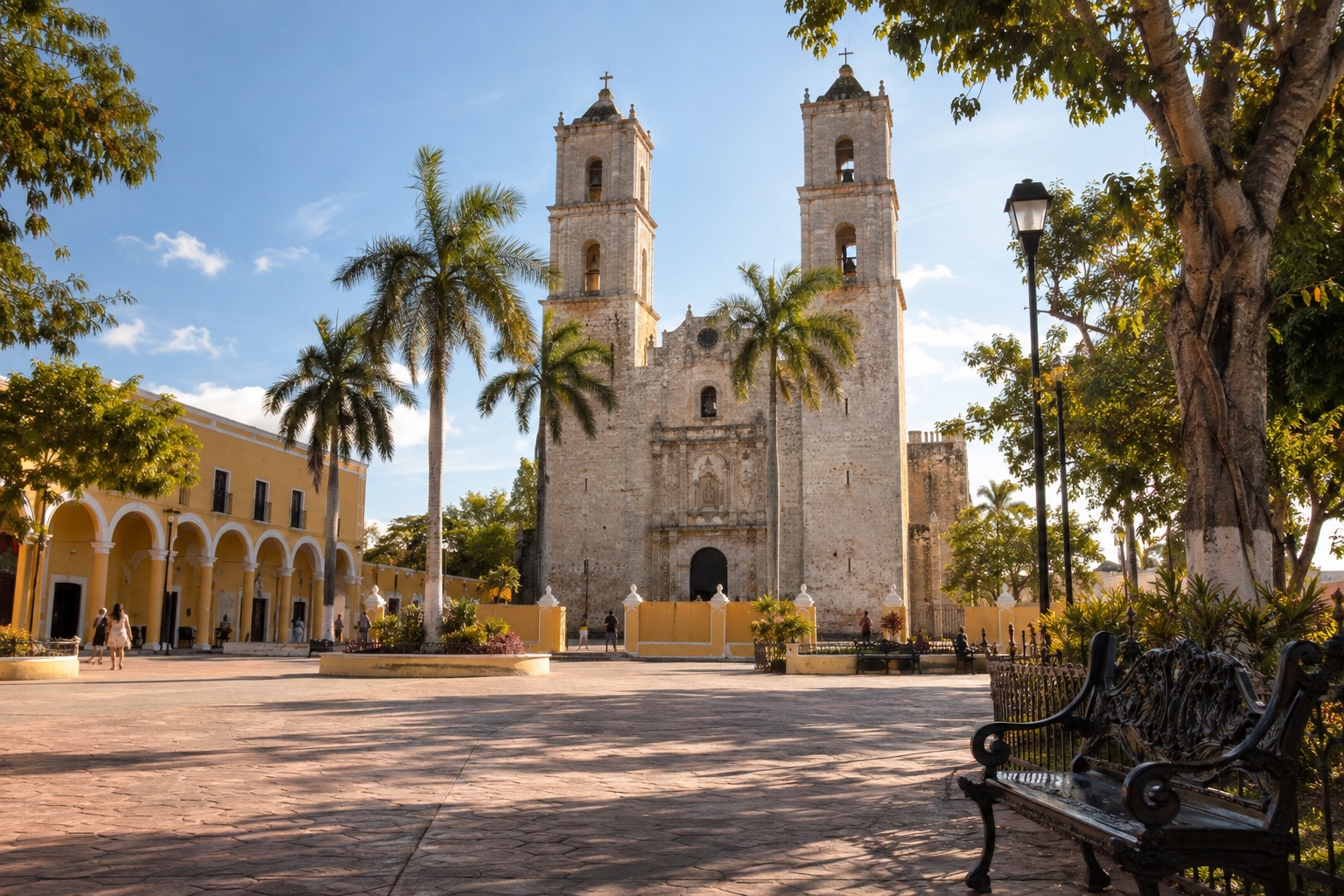 Wide sunlit plaza in front of a stone cathedral with two square towers