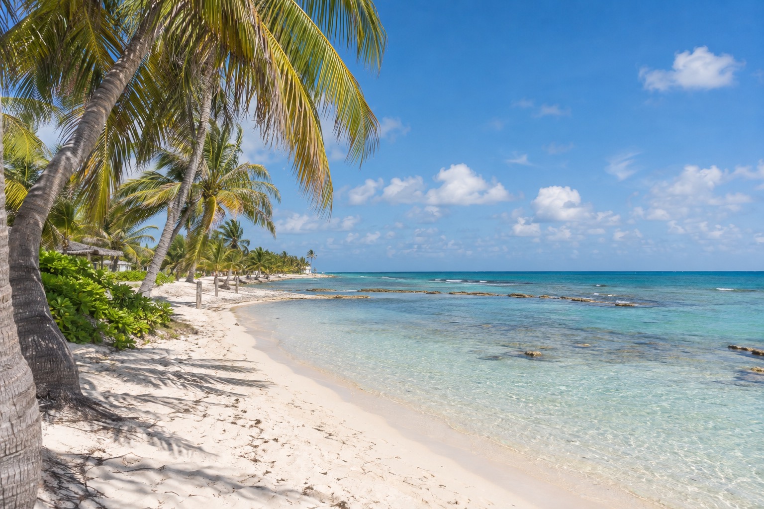 Beachfront promenade and palm-lined shore at Mahahual, Quintana Roo, with calm turquoise water