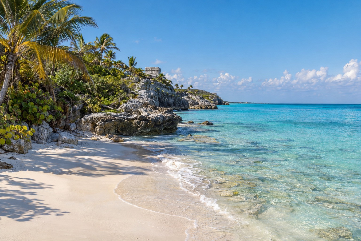 Weathered Maya stone building on a low cliff above turquoise Caribbean water