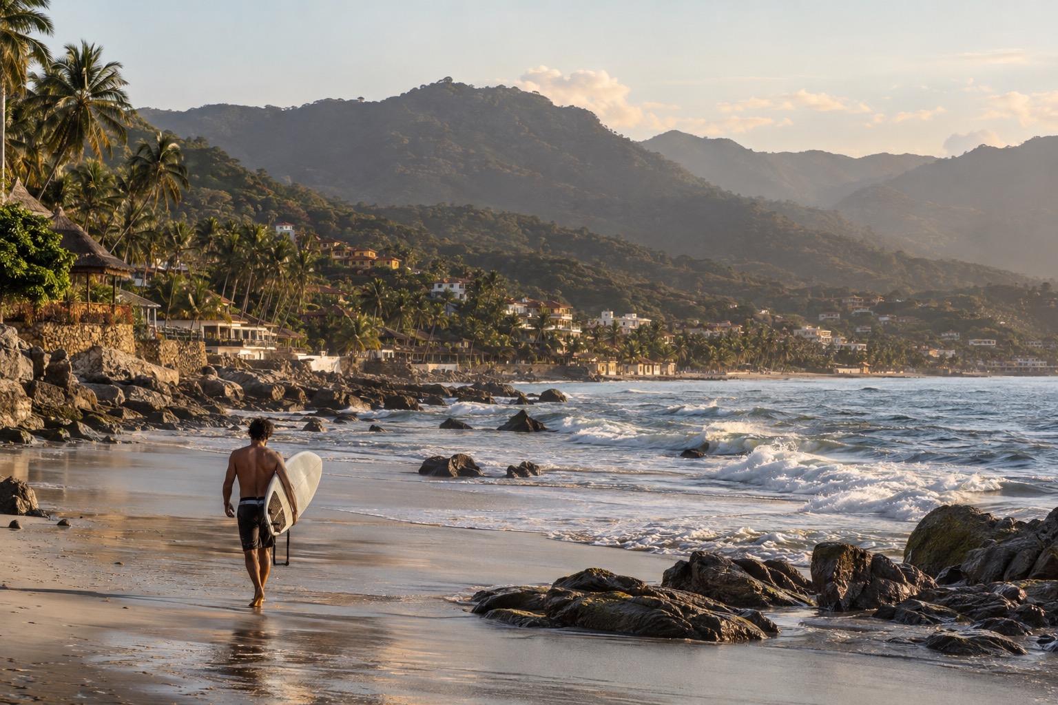 A surfer carrying a board along a palm-lined beach at low tide
