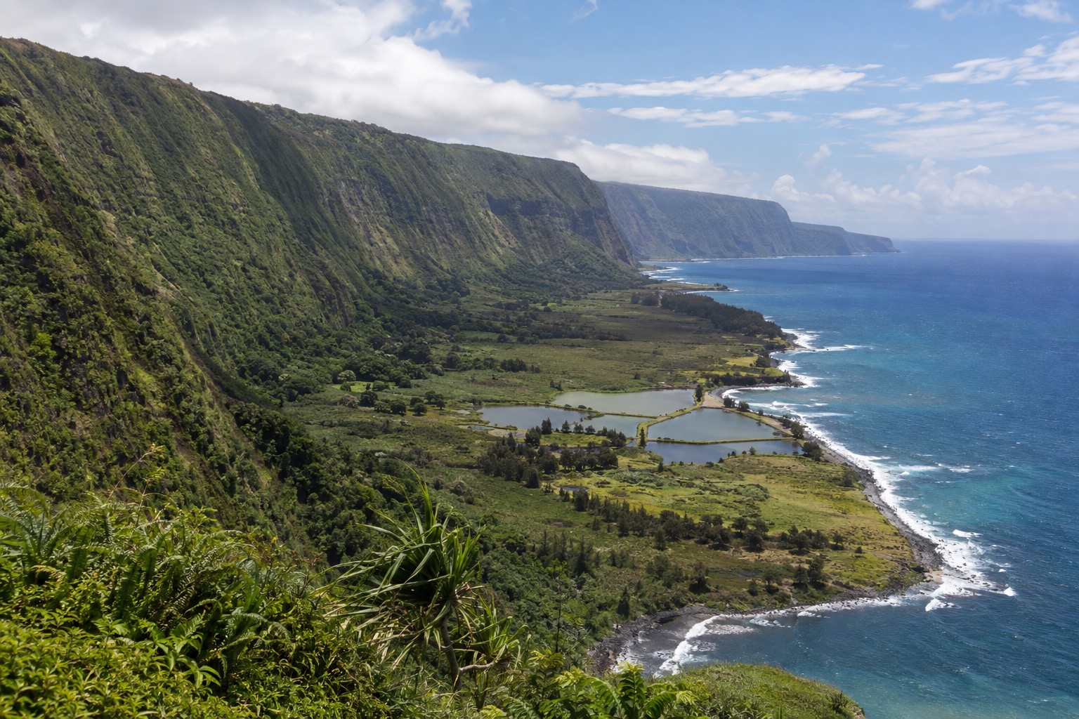 A coastal overlook with steep green cliffs above the Kalaupapa peninsula on Molokai