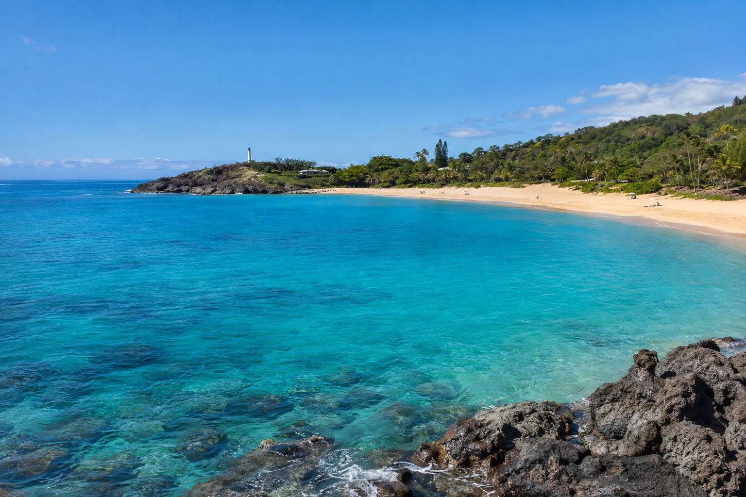 Calm turquoise water at Waimea Bay under a clear September sky, no big surf visible