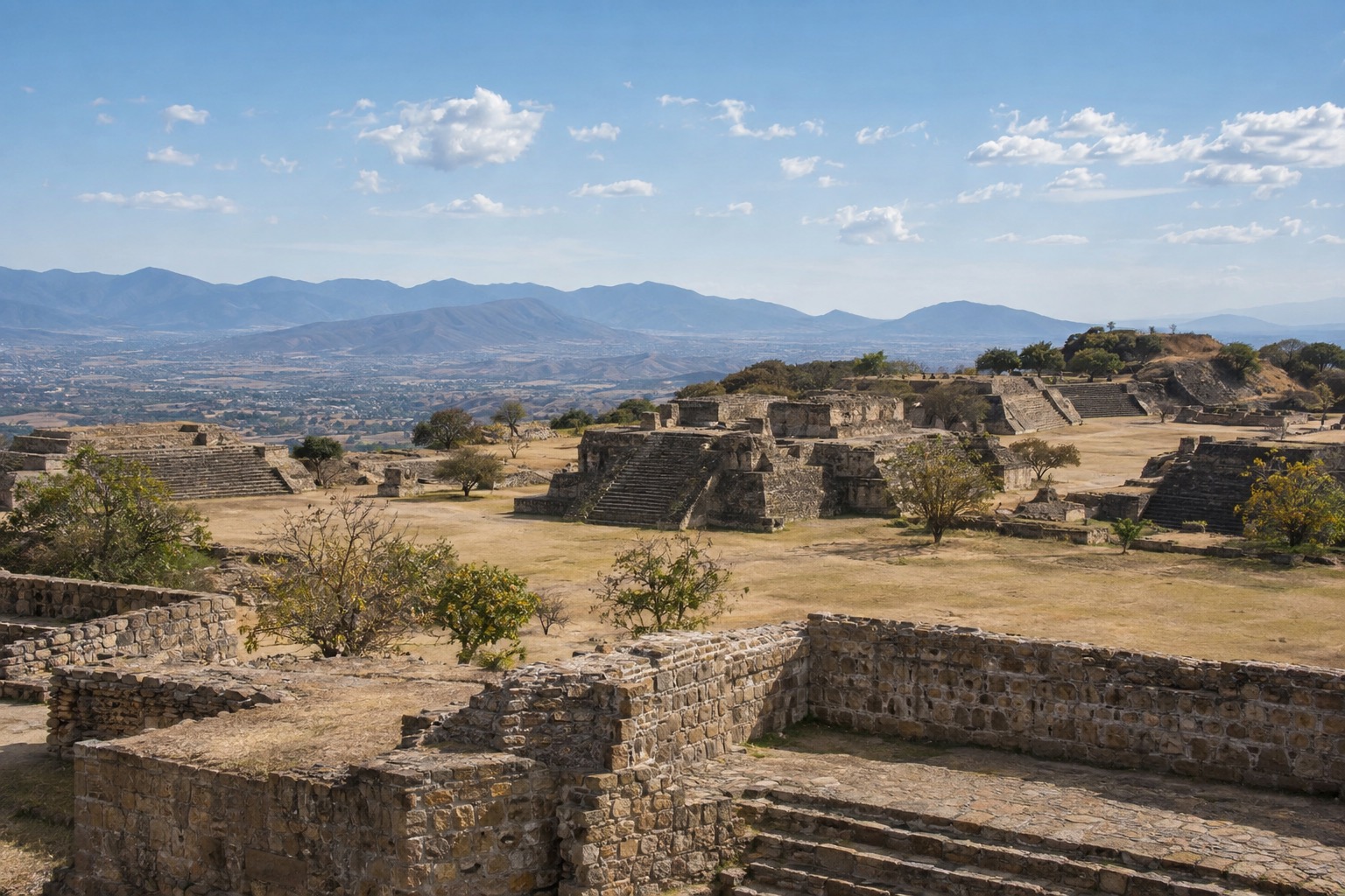 Stone plazas and platforms of Monte Alban under a bright sky above the Oaxaca valley