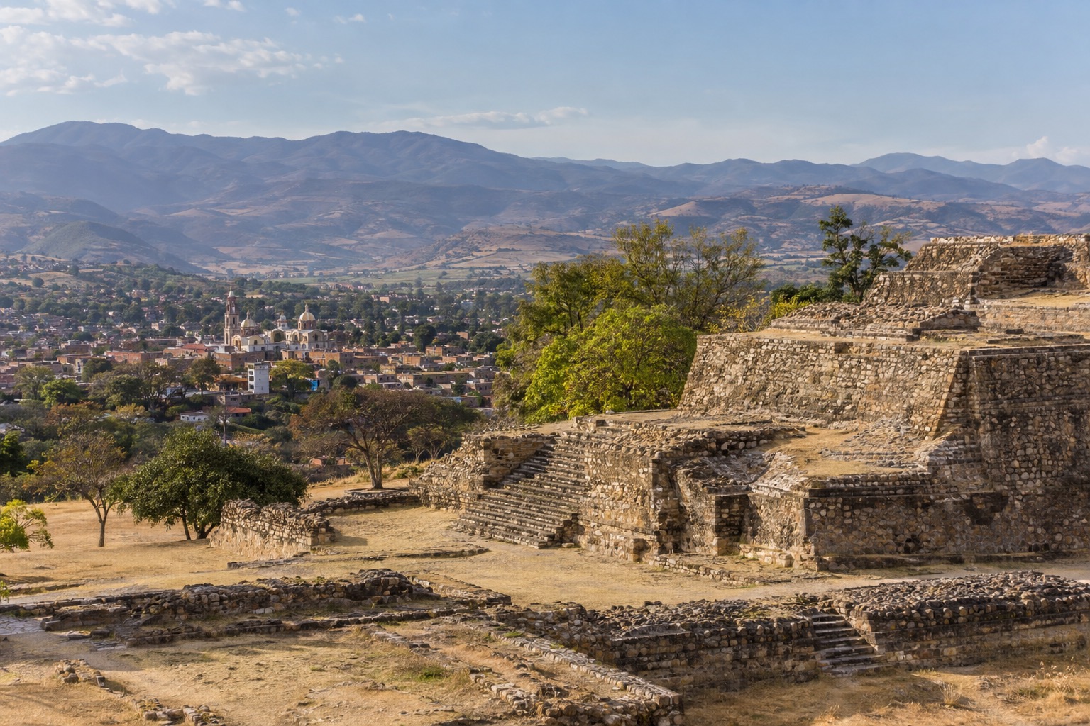 Stone platforms and stairways of a hilltop Zapotec archaeological site above a valley
