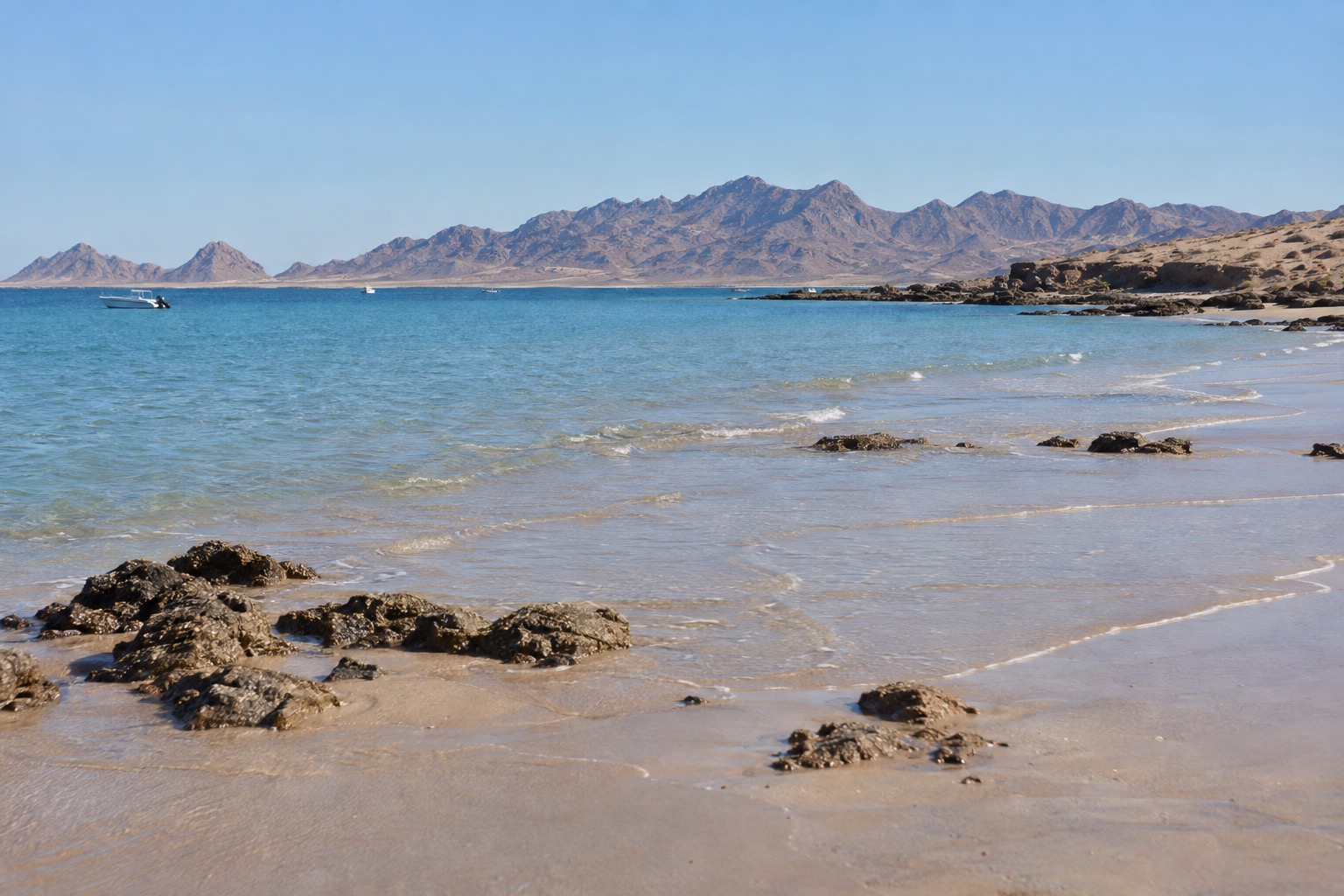Pale sand and calm blue water on the Sea of Cortez at Puerto Penasco in bright afternoon light