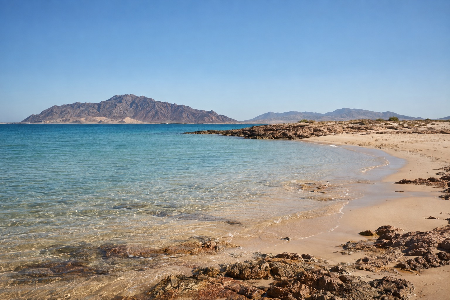 Wide sandy beach with shallow warm water and a low horizon on the Sea of Cortez