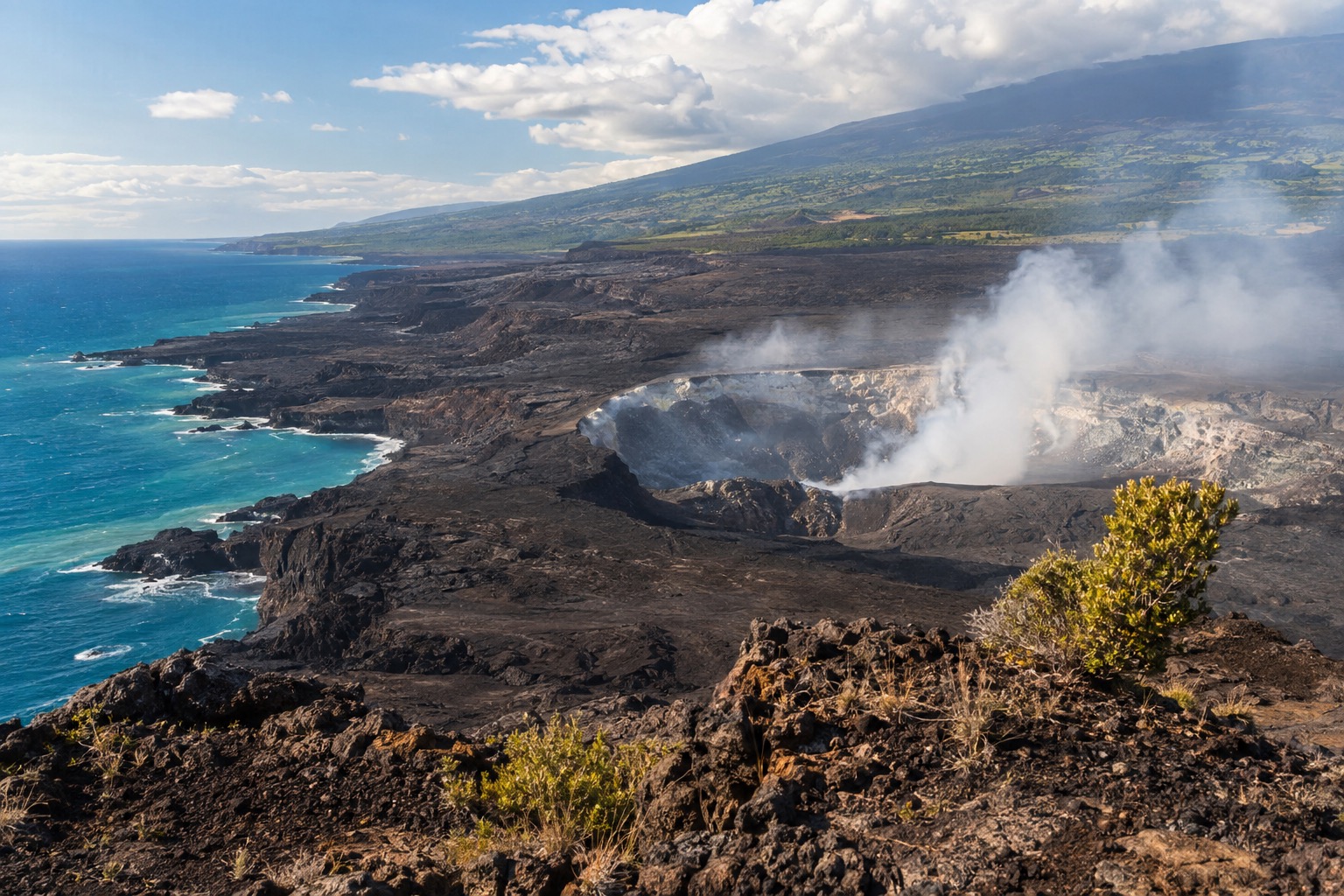 Steam rising from a volcanic crater rim under a partly cloudy sky, seen from a park overlook