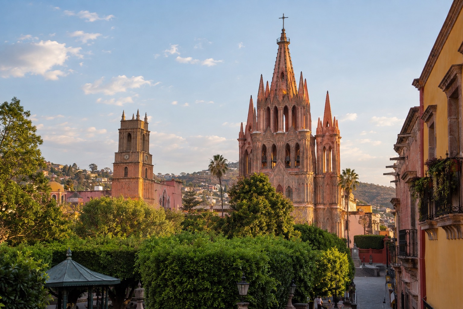 Pink neo-Gothic church towers rising above a tree-lined plaza in San Miguel de Allende