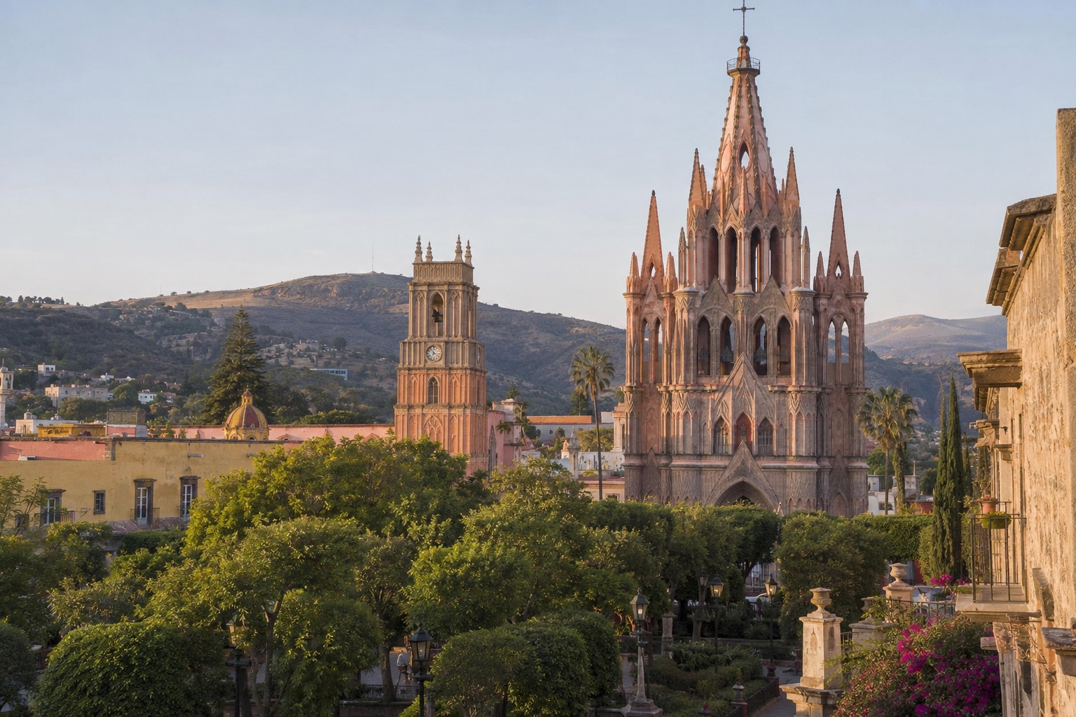 Twin pink neo-Gothic church towers rising above a tree-lined plaza