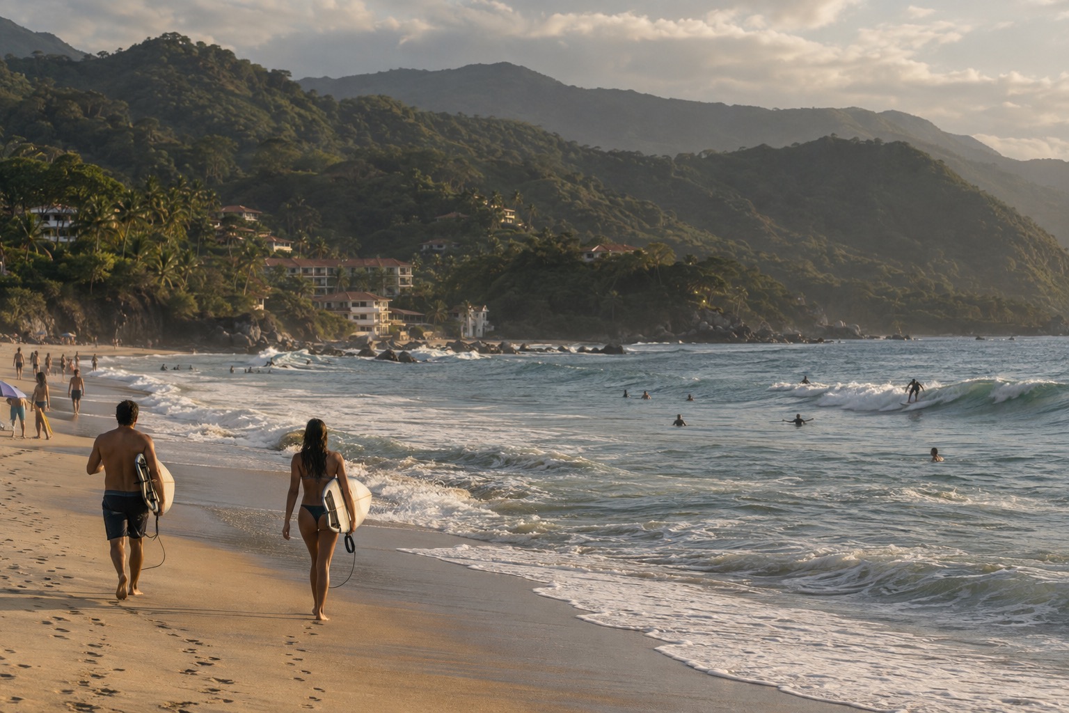 Surfers and beachgoers on a sandy bay with green hills behind, on the Nayarit coast