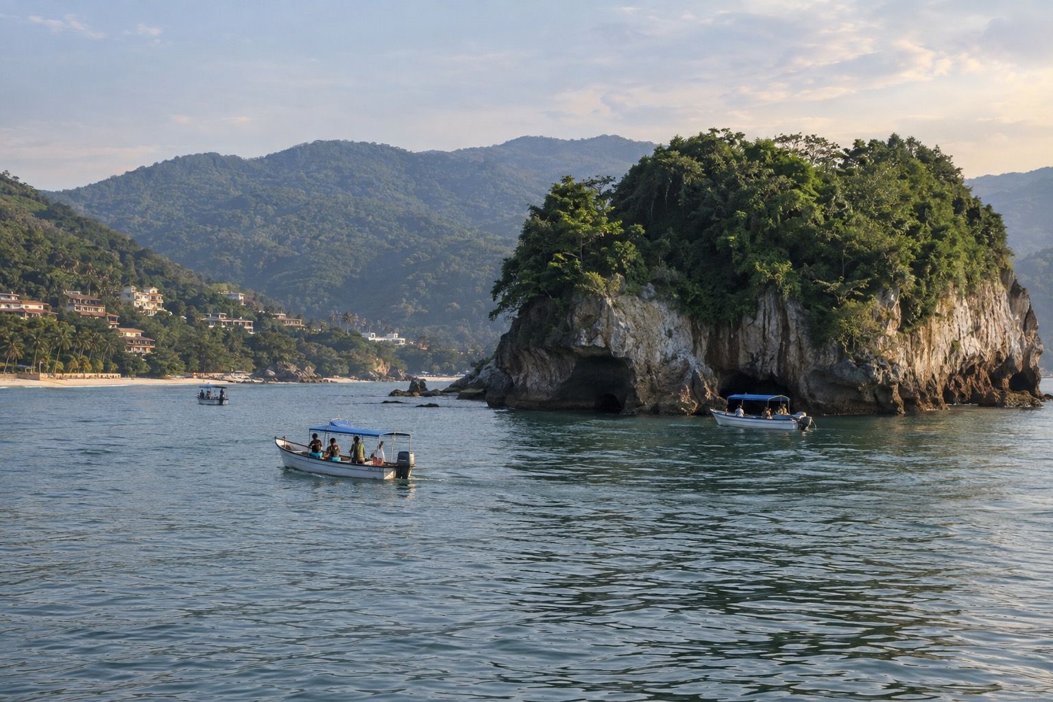 Small tour boats on calm water near a rocky island off the Nayarit coast