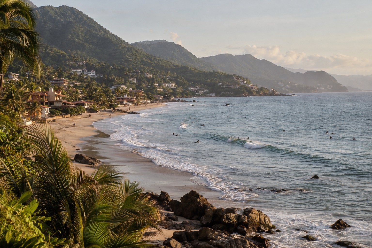 A curved beach at a Pacific surf town with small waves, surfers waiting offshore and palm trees along the sand