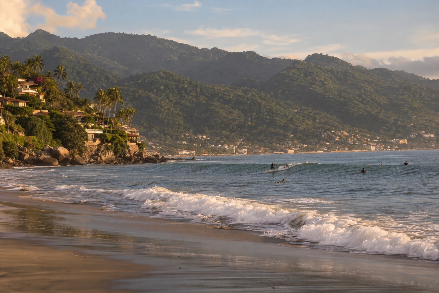 A palm-fringed surf beach on the Nayarit coast with small waves and a few surfers in the water