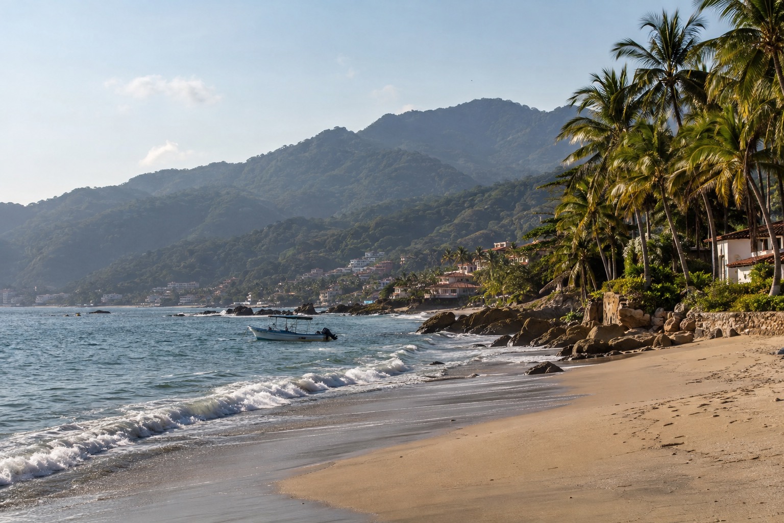 A warm-water sandy beach on the Nayarit coast with palm trees behind it and a small boat near the shoreline