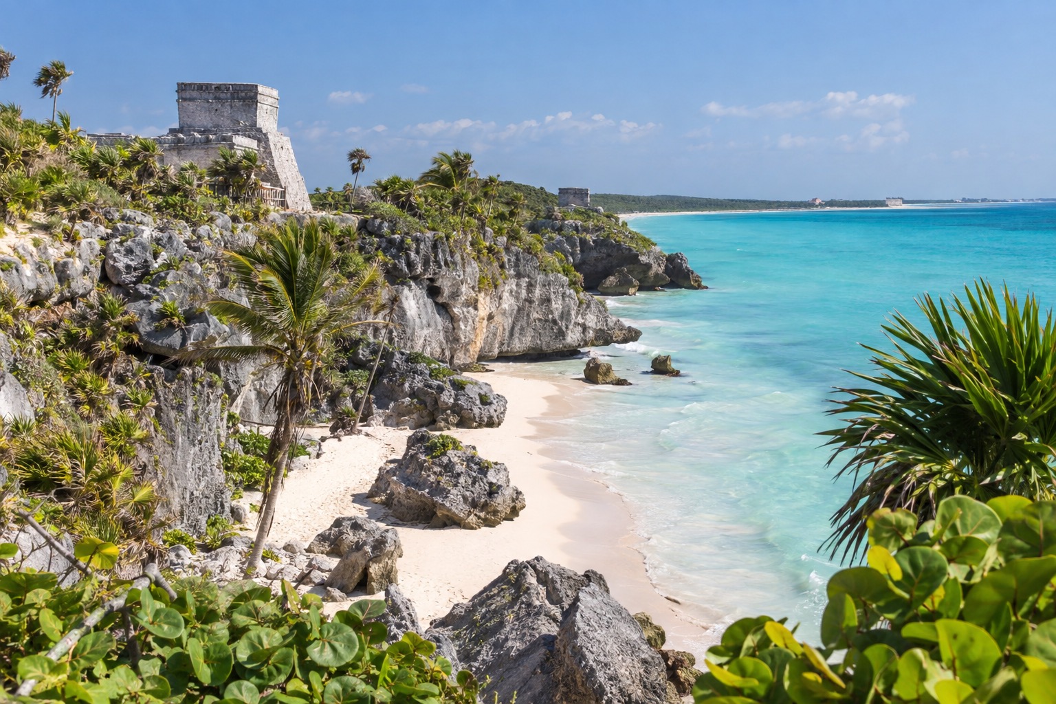 Ancient stone ruins on a coastal cliff above turquoise Caribbean water