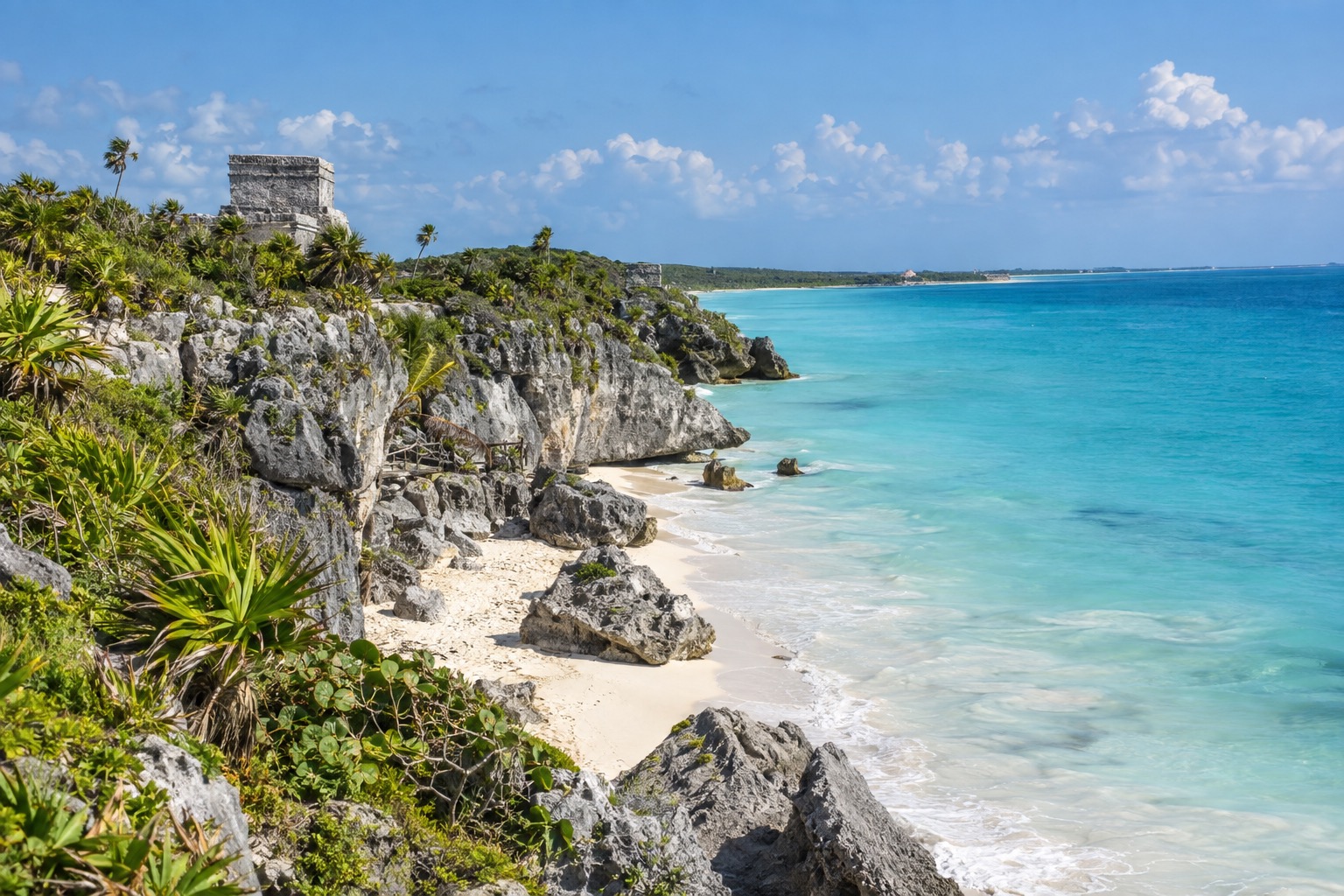 Stone ruins on a coastal cliff above turquoise water at Tulum