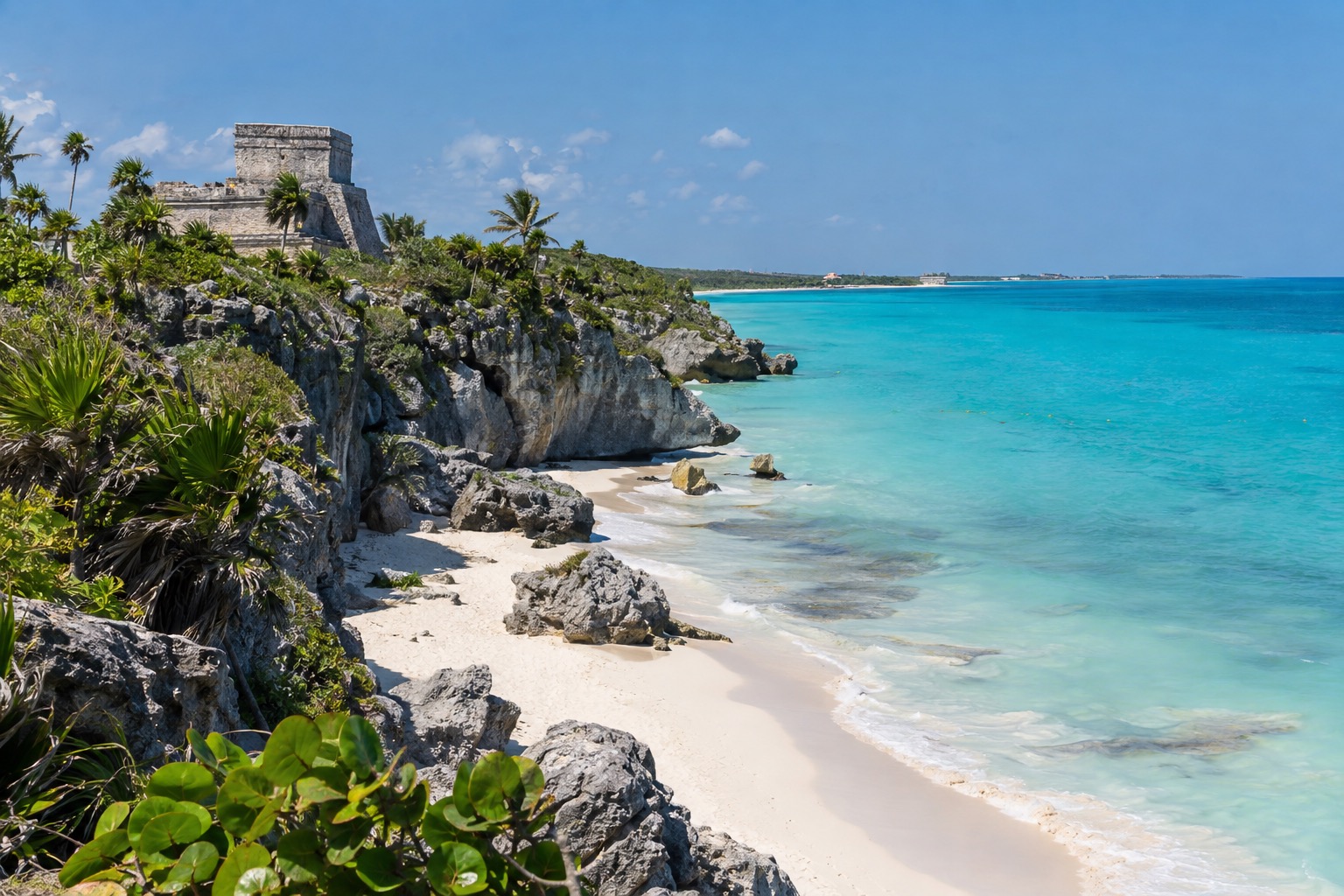 Stone Maya ruins on a cliff edge above turquoise Caribbean water