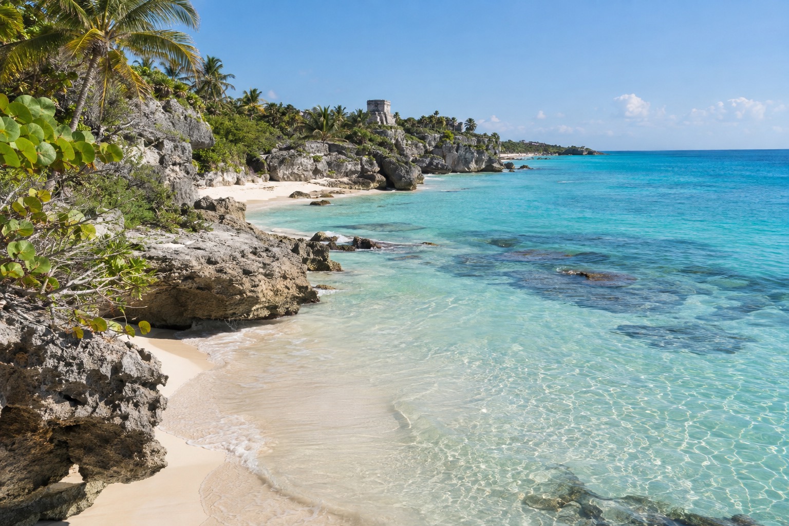 Clear shallow water over pale sand along the Tulum coastline